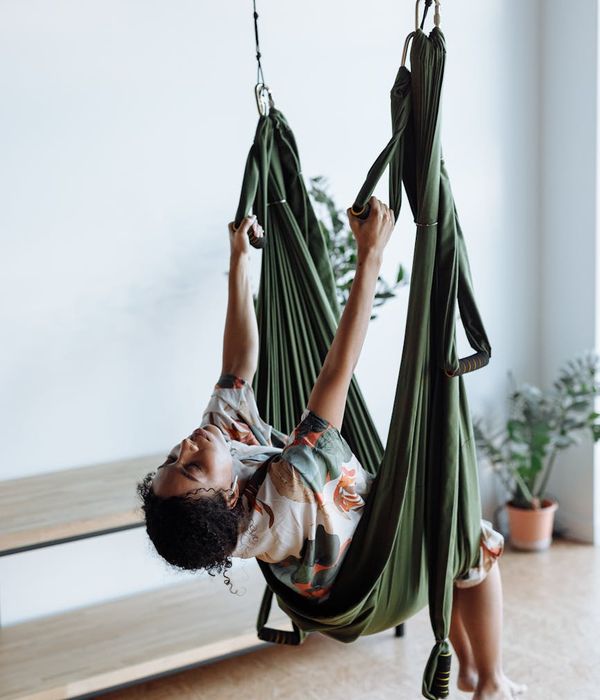 Woman in a serene yoga pose in a modern studio with soft lighting.